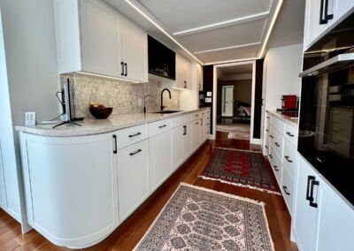 White curved-end galley kitchen with under-cabinet lighting, Toronto