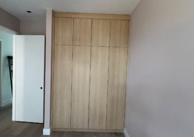 Wall-to-wall oak wardrobe with flat-panel doors