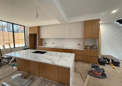 Rift-cut oak kitchen with white uppers and a marble waterfall island, Toronto