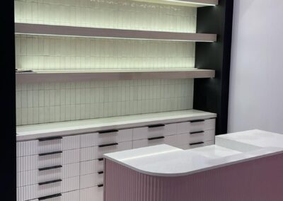 Beauty studio fluted drawer wall with lit floating shelves