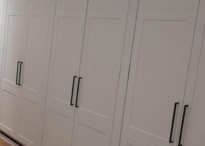 Floor-to-ceiling white shaker wardrobe wall