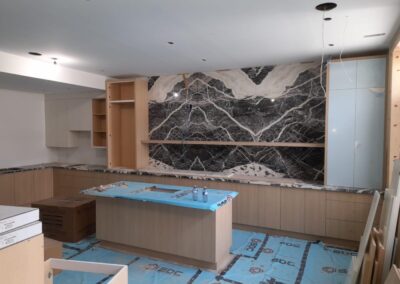 Oak kitchen with a bookmatched marble feature wall
