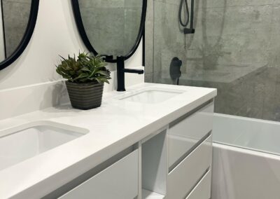 White bathroom vanity with an undermount sink and black faucet, Toronto