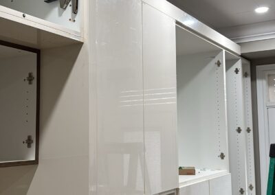 White gloss wall unit and walnut panels during install