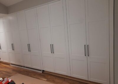 White shaker wardrobe wall with black pulls